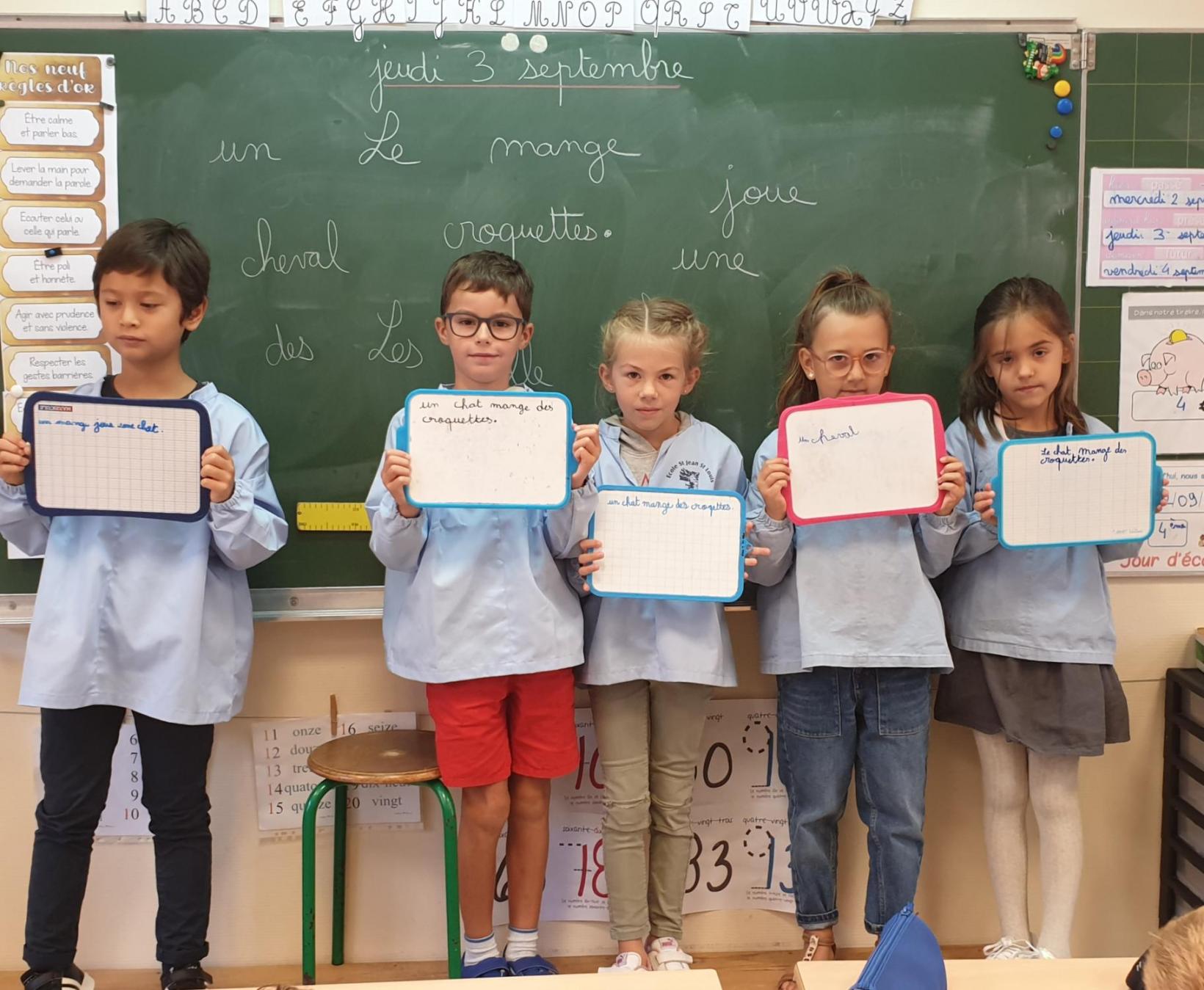 Certains élèves montrent leur phrase aux autres.