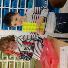 crayon aimanté pour attrper un à un les jetons dans les alvéoles d'un bac à glaçons. 